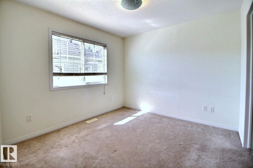 Neutral wall color, window with blinds, baseboard trim, and carpeted flooring - #18 4850 Terwillegar Cm Nw, Edmonton, AB 