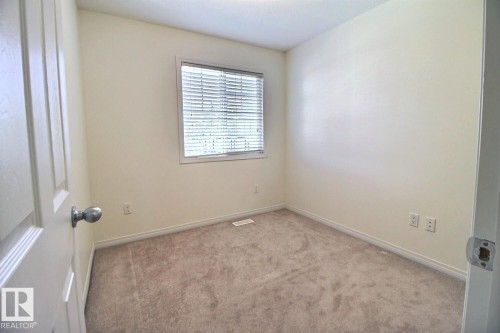 Window with horizontal blinds, neutral-toned carpeting, and light-colored walls - #18 4850 Terwillegar Cm Nw, Edmonton, AB 