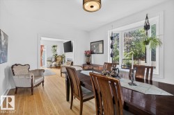 Hardwood flooring throughout, a bay window with a garden view, a cased opening, and a ceiling-mounted light fixture - 