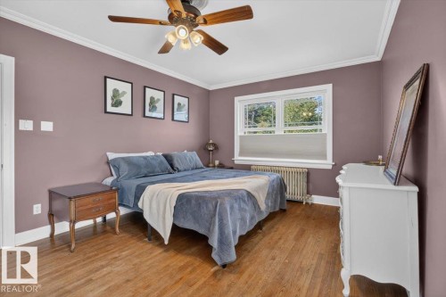 Hardwood flooring, crown molding, ceiling fan, window with natural light, and a radiator - 17107 80 Avenue Nw, Edmonton, AB 