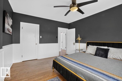 Wood-finish flooring, white paneled wainscoting, solid panel doors, and a ceiling fan with integrated lighting - 17107 80 Avenue Nw, Edmonton, AB 
