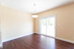 Wood-finish flooring with white trim and a neutral wall color - 