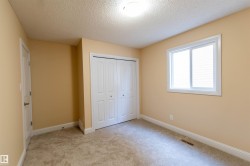 Wall-to-wall carpeting, bi-fold closet doors, white window trim, and a flush mount ceiling light fixture - 