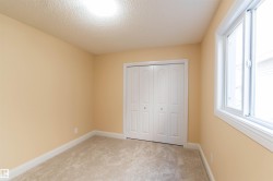 Neutral-toned wall finish, recessed ceiling lighting, carpeted flooring, white bi-fold closet doors, and a double-pane window - 