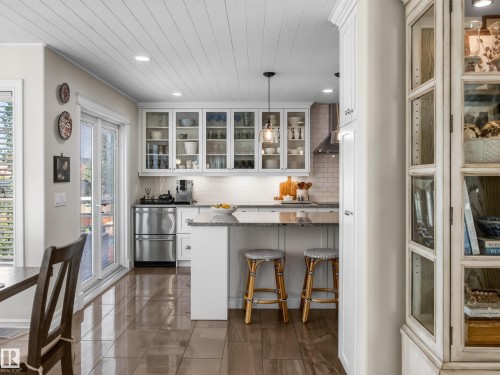 Kitchen featuring white cabinetry, stainless steel appliances, granite countertops, and wood-finish flooring - 1223 Appleton Close, Sherwood Park, AB 