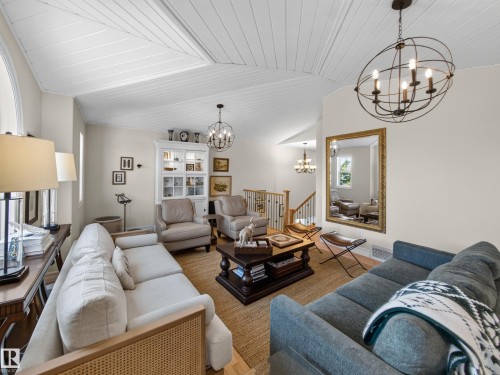 Vaulted ceiling with white paneling, two contemporary spherical chandeliers, light-toned walls, and wood-finish flooring - 1223 Appleton Close, Sherwood Park, AB 
