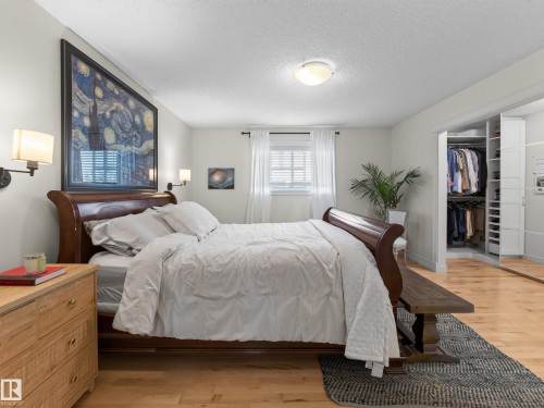 Light wood-finish flooring, built-in closet organization system, window with horizontal blinds, wall-mounted light fixtures, and a ceiling-mounted flush light fixture - 1223 Appleton Close, Sherwood Park, AB 