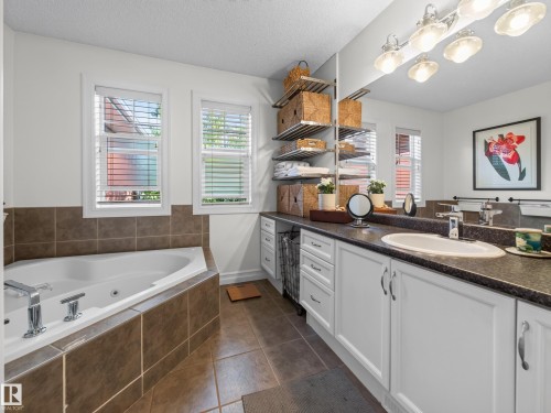 White vanity with dual sinks, a large mirror, and overhead lighting - 1223 Appleton Close, Sherwood Park, AB 