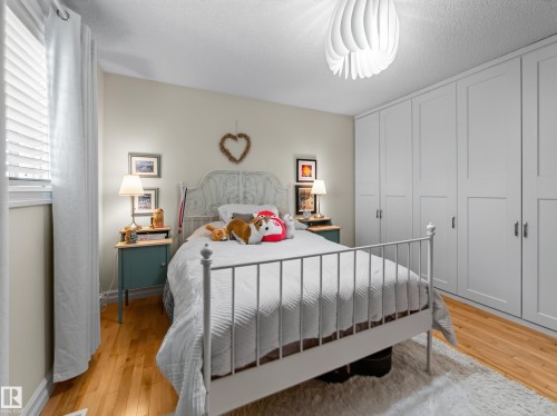 Hardwood flooring, window with blinds, decorative ceiling light fixture, panel-style built-in cabinetry with silver-tone hardware, and painted walls - 1223 Appleton Close, Sherwood Park, AB 