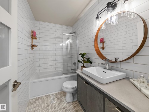 Subway tile walls, white bathtub with a glass shower screen, and a penny tile floor - 1223 Appleton Close, Sherwood Park, AB 