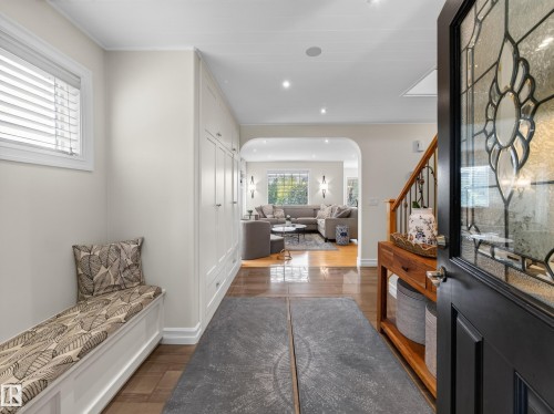 Leaded glass entry door, wood-finish flooring, built-in storage cabinetry, recessed lighting, and an arched entryway - 1223 Appleton Close, Sherwood Park, AB 