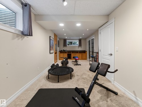 Carpeted lower level featuring recessed lighting, a built-in wood-finish cabinet, and a white paneled door - 1223 Appleton Close, Sherwood Park, AB 