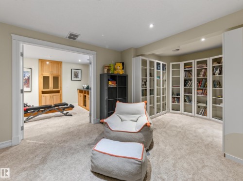 Carpeted room with recessed lighting and built-in white cabinetry with glass doors - 1223 Appleton Close, Sherwood Park, AB 