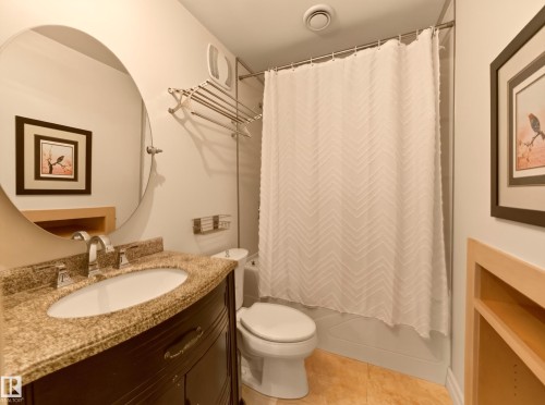 Dark-finish vanity with an oval undermount sink and a speckled countertop - 1223 Appleton Close, Sherwood Park, AB 