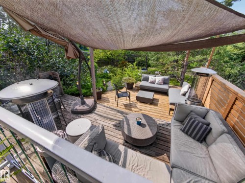 Expansive outdoor deck featuring wood flooring, a slatted wood privacy screen, and an overhead shade structure - 1223 Appleton Close, Sherwood Park, AB 