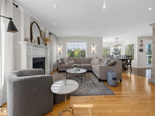 Hardwood flooring, recessed lighting, decorative fireplace with mantel, dual wall sconces, and bay windows - 1223 Appleton Close, Sherwood Park, AB 
