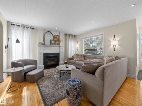 Living area featuring wood-finish flooring, a white mantel fireplace, and recessed ceiling lights - 1223 Appleton Close, Sherwood Park, AB 