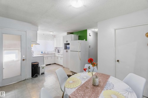Kitchen featuring white cabinetry, a built-in microwave, and tile flooring - 13408 67 Street Nw, Edmonton, AB 