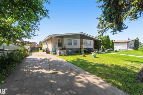 Single-story residence featuring a concrete driveway and an expansive front lawn - 13408 67 Street Nw, Edmonton, AB 