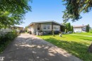 Single-story residence featuring a concrete driveway and an expansive front lawn - 13408 67 Street Nw, Edmonton, AB 
