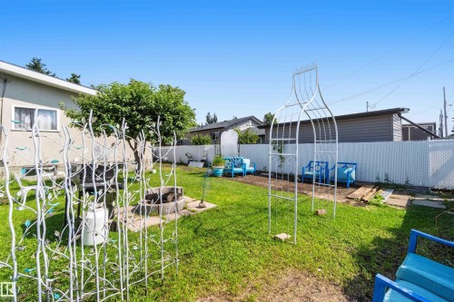 Expansive backyard with a manicured lawn, established privacy fencing, and a built-in fire pit - 13408 67 Street Nw, Edmonton, AB 