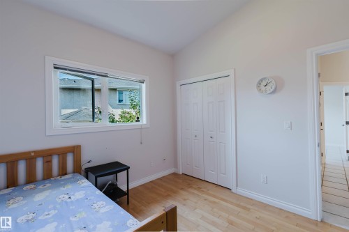Wood-finish flooring, white bi-fold closet doors, and light-toned walls - 8517 156 Avenue Nw, Edmonton, AB 