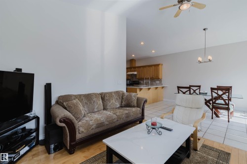 Wood-finish flooring, ceiling fan, recessed lighting, and a dining area with a linear pendant light - 8517 156 Avenue Nw, Edmonton, AB 