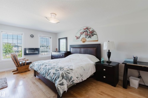 Hardwood flooring, wall-mounted electric fireplace, two windows with grid patterns, ceiling-mounted light fixture - 8517 156 Avenue Nw, Edmonton, AB 