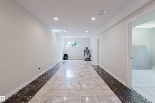 Recessed lighting, window, white walls, and a tiled floor with a central accent strip - 8517 156 Avenue Nw, Edmonton, AB 