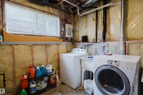 Window with blinds, utility sink, exposed ceiling joists, and visible insulation - 8517 156 Avenue Nw, Edmonton, AB 