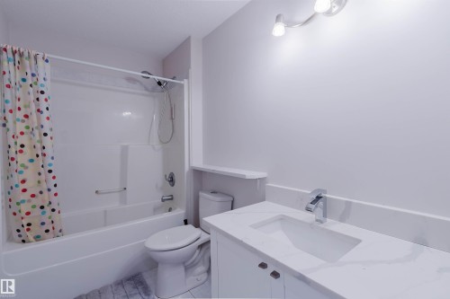 White vanity with integrated sink, chrome faucet, and quartz-finish countertop - 8517 156 Avenue Nw, Edmonton, AB 