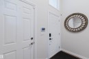 White paneled interior doors, wall-mounted smart thermostat, and high ceilings with transom window - 8517 156 Avenue Nw, Edmonton, AB 