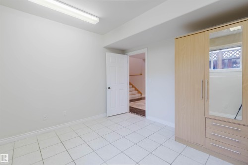 White tile flooring, white walls, and a white paneled door - 8517 156 Avenue Nw, Edmonton, AB 