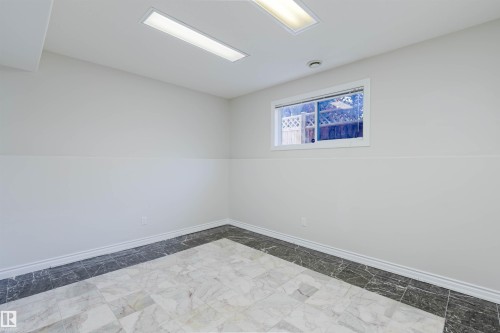 Recessed ceiling lighting, tiled flooring with contrasting border, white trim, and a window with white casing - 8517 156 Avenue Nw, Edmonton, AB 