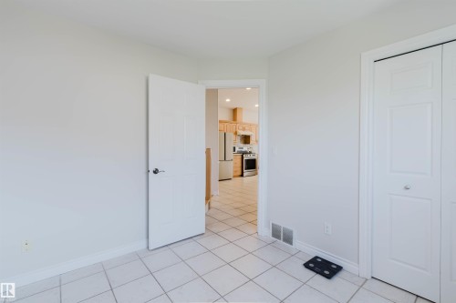 White tile flooring and a white paneled closet - 8517 156 Avenue Nw, Edmonton, AB 