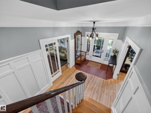 Foyer with wood-finish flooring, white wainscoting, and a full-light entry door with sidelights - 11108 64 Street Nw, Edmonton, AB - Indoor Photo Showing Other Room