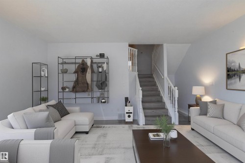 Open living area featuring wood-finish flooring and a staircase with white railings - #37 3811 85 St Nw, Edmonton, AB 