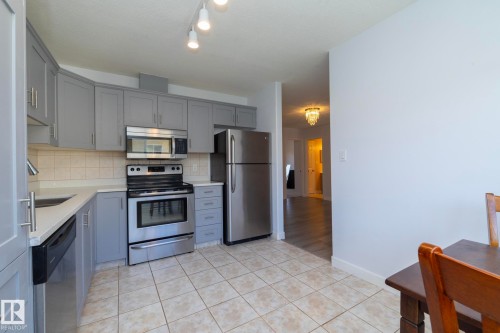 Kitchen featuring light gray cabinetry, stainless steel appliances, light-toned countertops, and tile flooring - #37 3811 85 St Nw, Edmonton, AB 