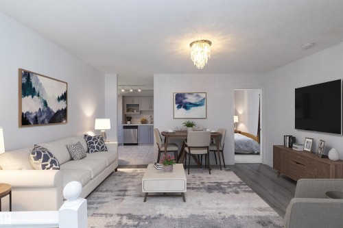 Open-concept living space with wood-finish flooring, a contemporary chandelier, and recessed lighting in the kitchen - #37 3811 85 St Nw, Edmonton, AB 