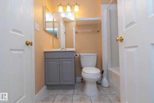 Bathroom featuring a single vanity, undermount sink, wall-mounted light fixture, and a combination tub and shower - #37 3811 85 St Nw, Edmonton, AB 
