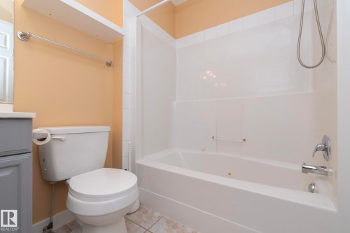 White soaking tub with integrated shower, chrome fixtures, and a tiled floor - #37 3811 85 St Nw, Edmonton, AB 