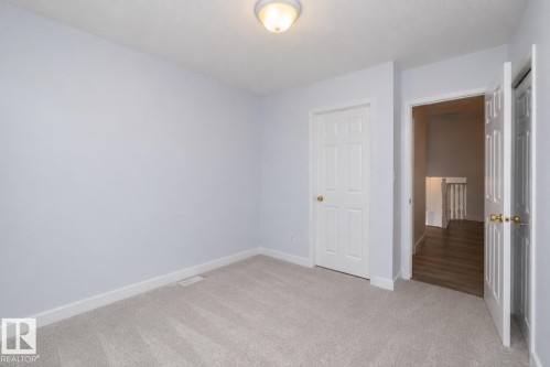 Neutral-toned wall paint, recessed ceiling light fixture, white interior doors, and light gray carpeting - #37 3811 85 St Nw, Edmonton, AB 