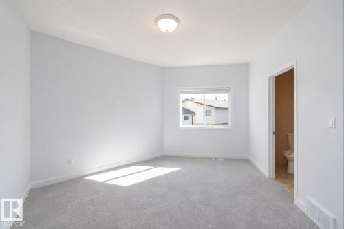 Light gray wall paint, gray carpeting, single window, flush mount ceiling light fixture, white trim - #37 3811 85 St Nw, Edmonton, AB 