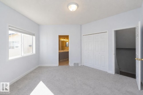 Light-colored wall-to-wall carpeting, white walls, double-pane window, bi-fold closet doors, and recessed ceiling light fixture - #37 3811 85 St Nw, Edmonton, AB 