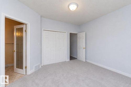 Light gray wall finish with white trim, soft gray carpeting, and a flush-mount ceiling light fixture - #37 3811 85 St Nw, Edmonton, AB 