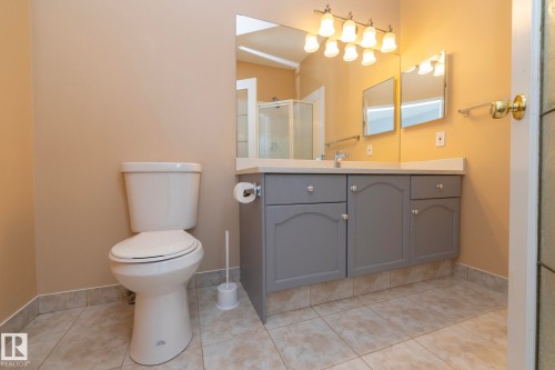 Bathroom featuring a vanity with gray cabinetry, a light-toned countertop, and a double mirror - #37 3811 85 St Nw, Edmonton, AB 