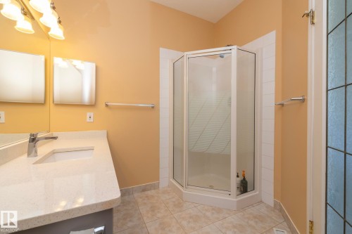 Integrated vanity with an undermount sink, a corner shower enclosure, and tiled flooring - #37 3811 85 St Nw, Edmonton, AB 