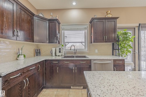 Large kitchen with walk-thru pantry, updated appliances, quartz island and unobstructed view of the ravine - 57 Homestead Crescent Nw, Edmonton, AB 