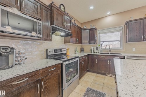 Large kitchen with walk-thru pantry, updated appliances, quartz island and unobstructed view of the ravine - 57 Homestead Crescent Nw, Edmonton, AB 