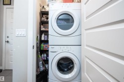 Dedicated laundry area featuring a stacked washer and dryer unit - 